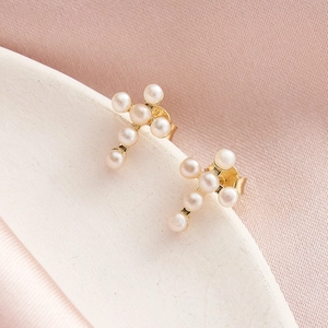 Detail of S925 silver gold-plated cross earrings featuring delicate natural white pearls