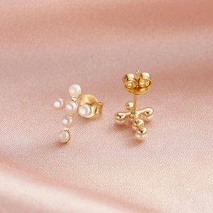 Detail of S925 silver gold-plated cross earrings with small white freshwater pearls