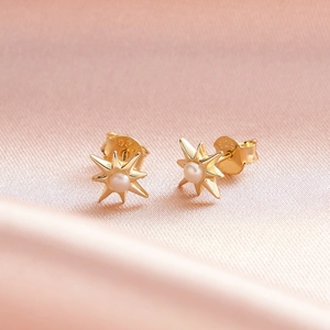 Macro view of gold-plated S925 sterling silver star earrings with white pearls