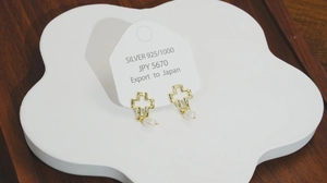 Détail de boucles d'oreilles croix en argent S925 doré avec perles blanches naturelles