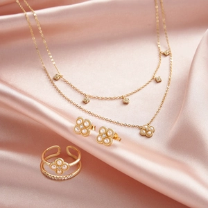 Détail de parure collier double trèfle boucles d'oreilles et bague sur soie