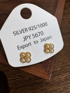 Détail macro de boucles d'oreilles trèfle en argent S925 avec perles et cristal