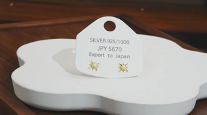 Detail of gold star stud earrings with white pearl inlay on S925 silver base
