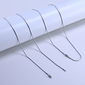 Macro shot of 925 sterling silver snake chains with durable lobster clasps on white display