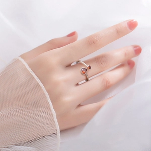 Detail of adjustable silver ring with two red heart-shaped stones on model hand