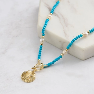 Detail of shell pendant necklace with blue turquoise beads and freshwater pearls