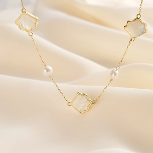 Détail d'un collier en argent S925 doré avec des fleurs en nacre et perles d'eau douce
