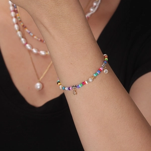 Vue rapprochée du bracelet en argent S925 avec perles de verre colorées et breloques