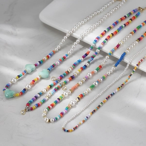Détail de colliers bohèmes faits main avec des perles de verre colorées et perles