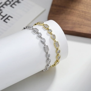 Elegant gold and silver geometric bracelets with multi-cut sparkling zircons on white stands