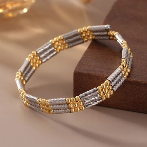 Detail of s925 silver and gold two-tone bracelet with twisted rope texture and round beads