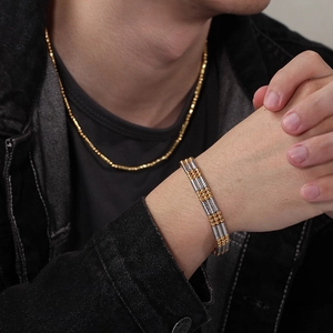 Three-strand twisted cable steel bracelet with gold beads and matching thin gold chain