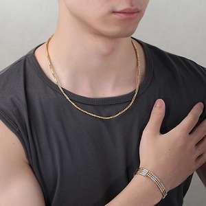 Close-up of men's gold bamboo necklace and two-tone industrial style bracelet set
