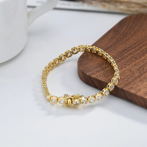 Vue détaillée du bracelet tennis doré avec zircons carrés et fermoir à boucle déployante