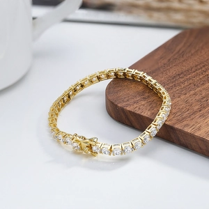 Gros plan du bracelet tennis doré avec zircons sur un support en bois de noyer