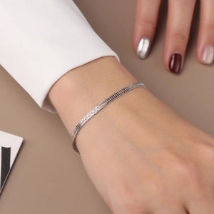 Close-up of a minimalist S925 sterling silver woven chain bracelet on a woman's wrist