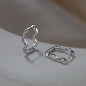 Macro shot of S925 sterling silver wavy earrings with small cubic zirconia stones