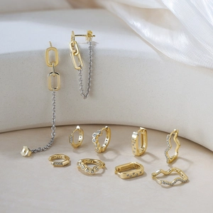 Detail of S925 sterling silver gold-plated wavy earrings with shimmering zircon stones
