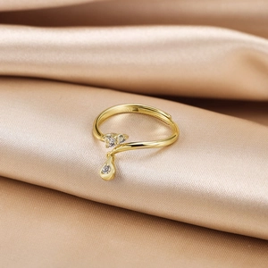 Macro shot of s925 silver gold-plated ring with zircon drops on champagne satin