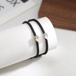 Adjustable black woven friendship bracelets with gold and silver cubic zirconia teardrop charms