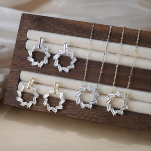 Détails de bijoux géométriques en or et argent sertis de cristaux étincelants taille baguette