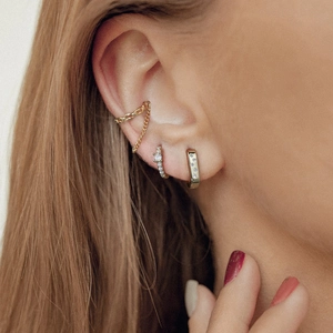 Macro shot of 925 silver gold hoop earrings with cubic zirconia stones on model