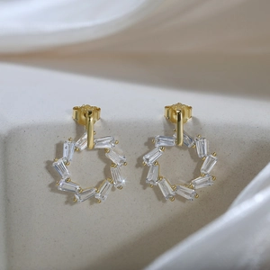 Gros plan du poinçon S925 sur des boucles d'oreilles dorées avec oxydes de zirconium