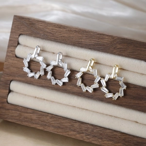 Boucles d'oreilles géométriques dorées et argentées avec zircon sur support en bois