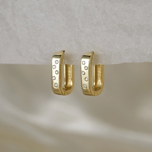 Detailed view of gold square hoop earrings with micro-set cubic zirconia on white card