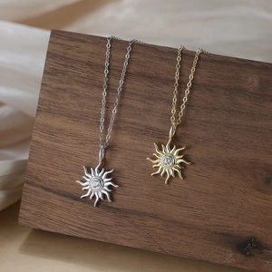 Colliers pendentifs tournesol dorés et argentés avec zircon sur support en bois