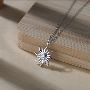 Gros plan détaillé d'un pendentif tournesol en argent avec un zircon cubique brillant