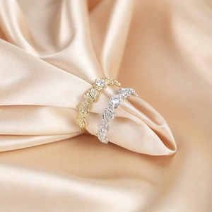 Detailed close-up of 925 silver rose rings with sparkling cubic zirconia on satin fabric