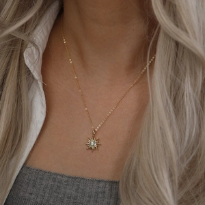 Gros plan détaillé d'un collier pendentif tournesol doré porté par un mannequin