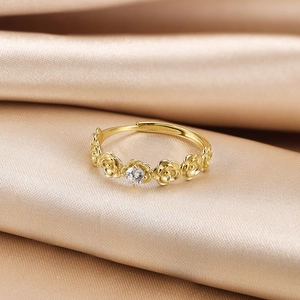 Detail of S925 sterling silver rose ring with sparkling central zircon on champagne silk
