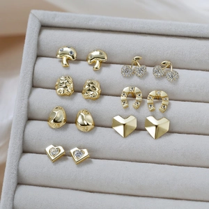 Detailed macro view of multiple vintage gold mushroom and cherry stud earring sets