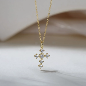Gros plan détaillé du collier croix en argent S925 doré serti de pierres scintillantes