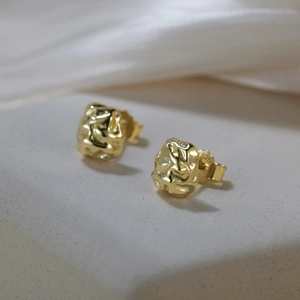 Gros plan du poinçon S925 sur boucles d'oreilles dorées à texture de métal liquide