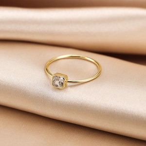 Detailed view of S925 silver gold ring with square cubic zirconia on champagne silk