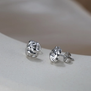 Vue macro des boucles d'oreilles S925 en argent à texture de lave sur présentoir
