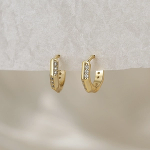 Macro view of 18K gold S925 sterling silver hoop earrings with zircon accents on gray paper
