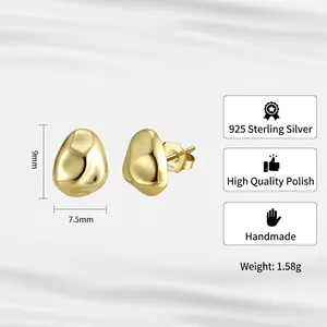 Irregular pebble-shaped S925 sterling silver gold earrings on white silk texture