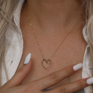 Collier cœur minimaliste en argent S925 doré porté par un mannequin sur chemise blanche