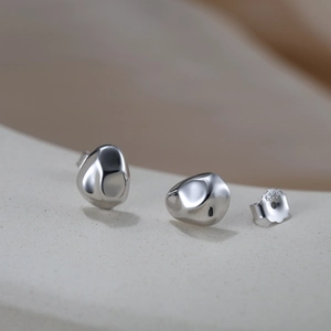 Macro shot of S925 sterling silver pebble earrings with polished liquid metal finish