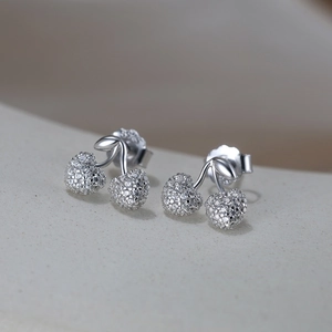 Detailed macro view of S925 sterling silver cherry earrings with sparkling pavé zircons