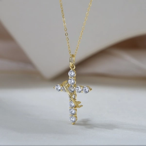 Macro shot of gold cross necklace with brilliant zircon stones and vintage thorn detail
