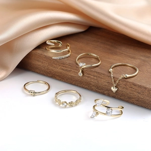 Set di sei anelli dorati minimalisti con dettagli di cuore in zircone e rose su seta