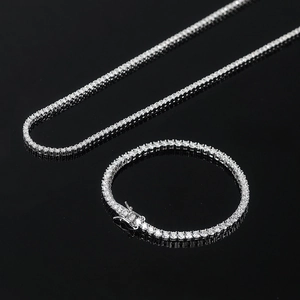 Macro shot of silver moissanite tennis necklace and bracelet set on black background