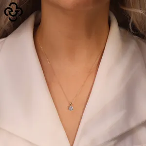 Detailed close-up of a s925 silver crown pendant with cubic zirconia on a gold chain