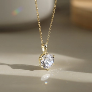 Detailed macro view of a six-prong silver necklace with a brilliant round zircon pendant