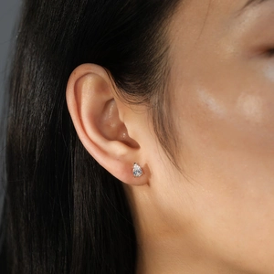 Close-up of 925 sterling silver pear-shaped zircon stud earring worn by a model